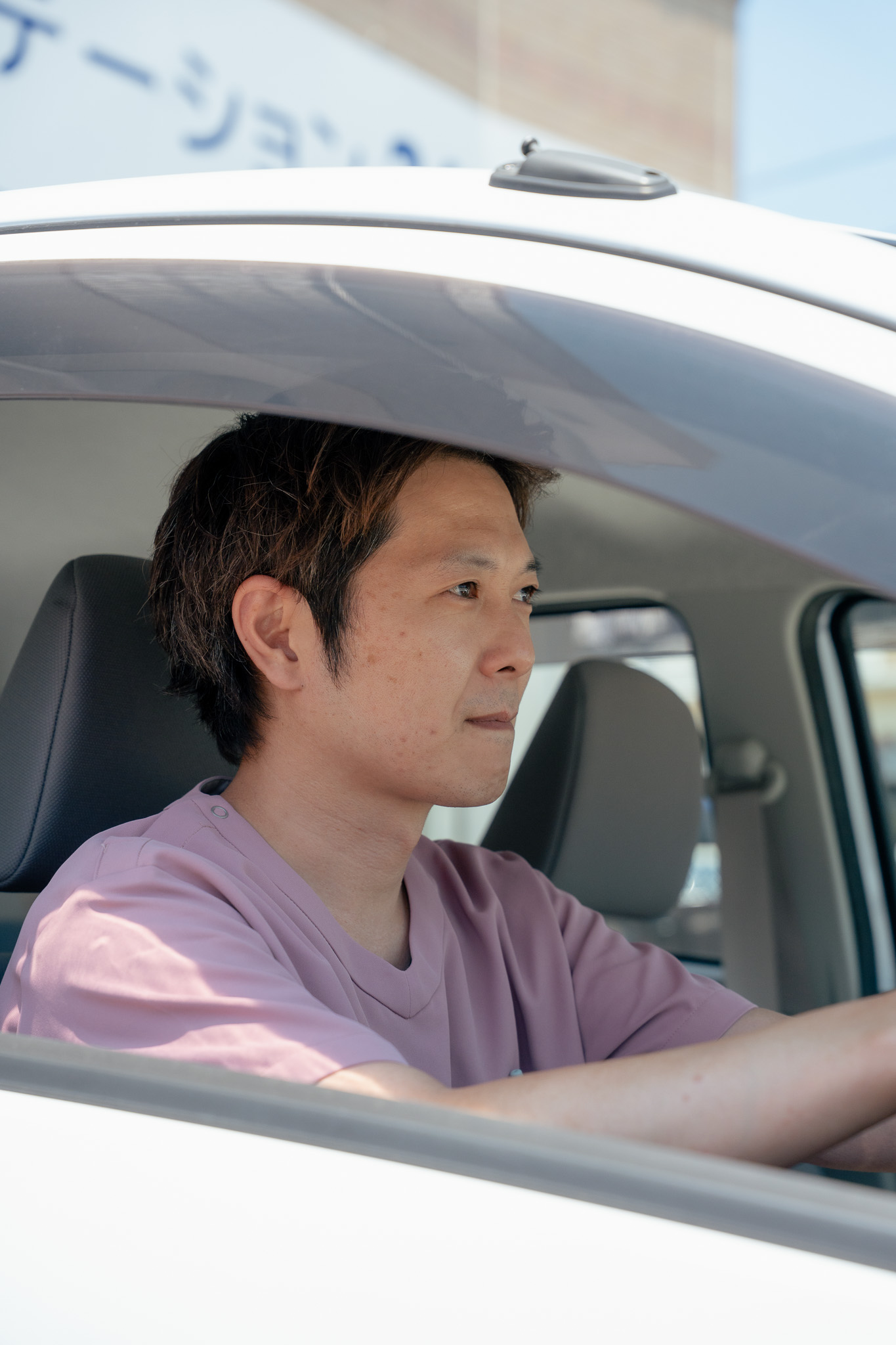 車の運転席に座るスタッフ
